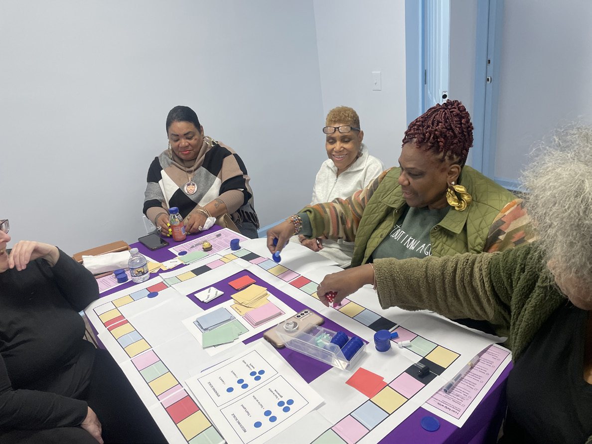 Grandmothers playing the Community Exchange board game