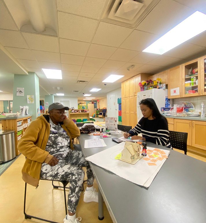 A grandmother and the researcher talking at a table in a community kitchen