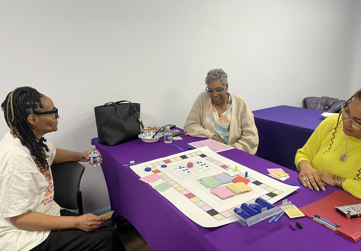 Grandmothers around the board game on a purple tablecloth